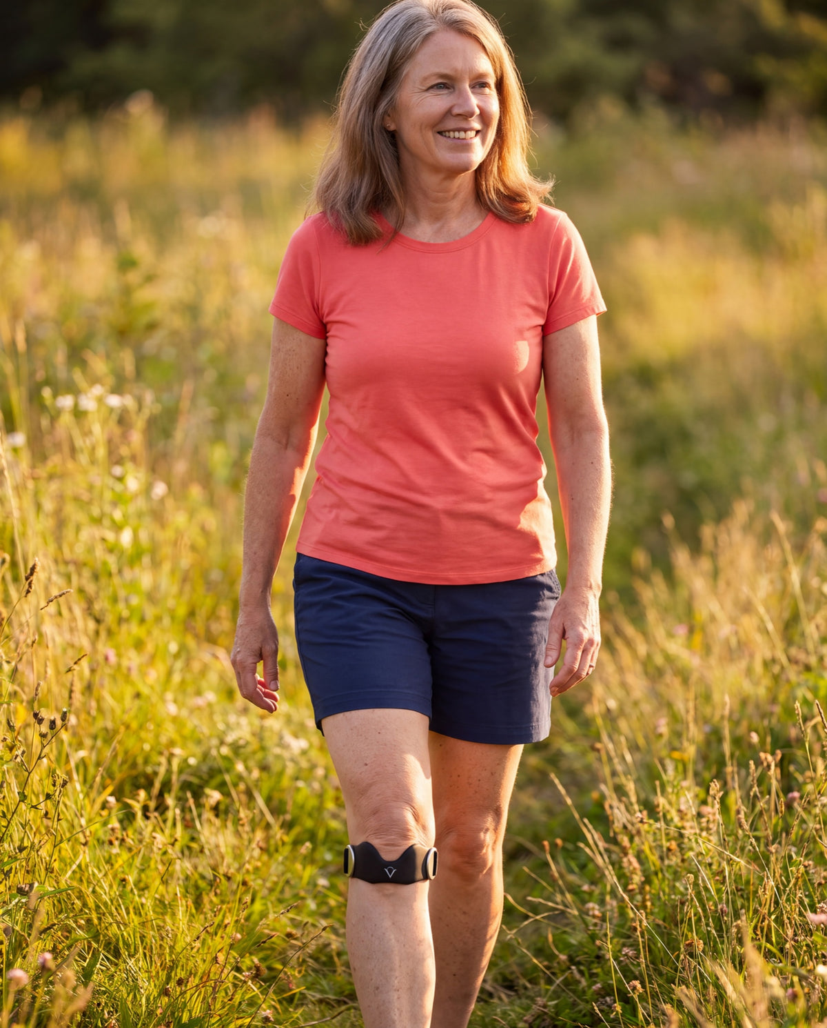 Woman walking a meadow trail wearing the Veranoe strap